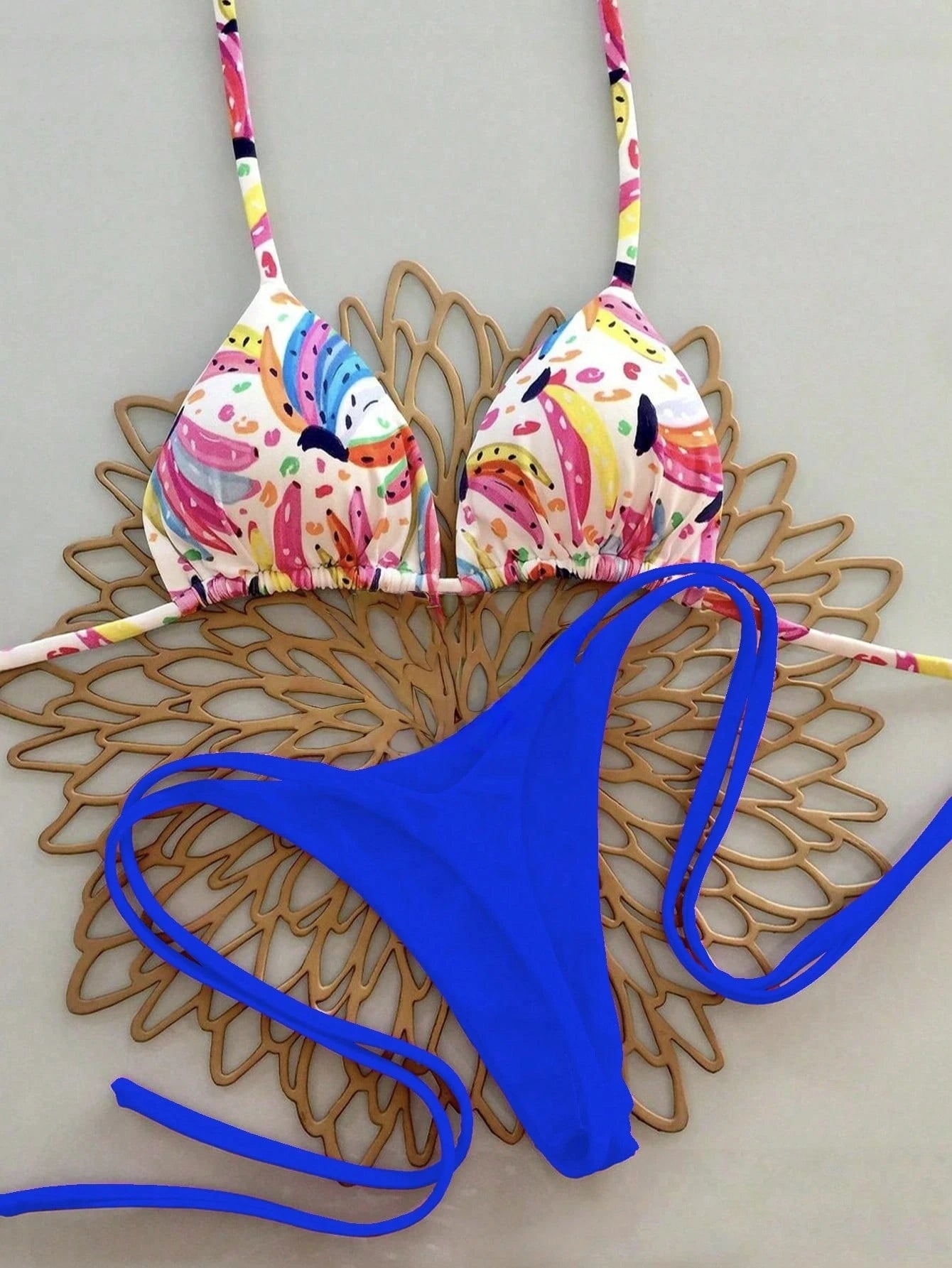 Colorful bikini top and blue bottom on a decorative wooden surface