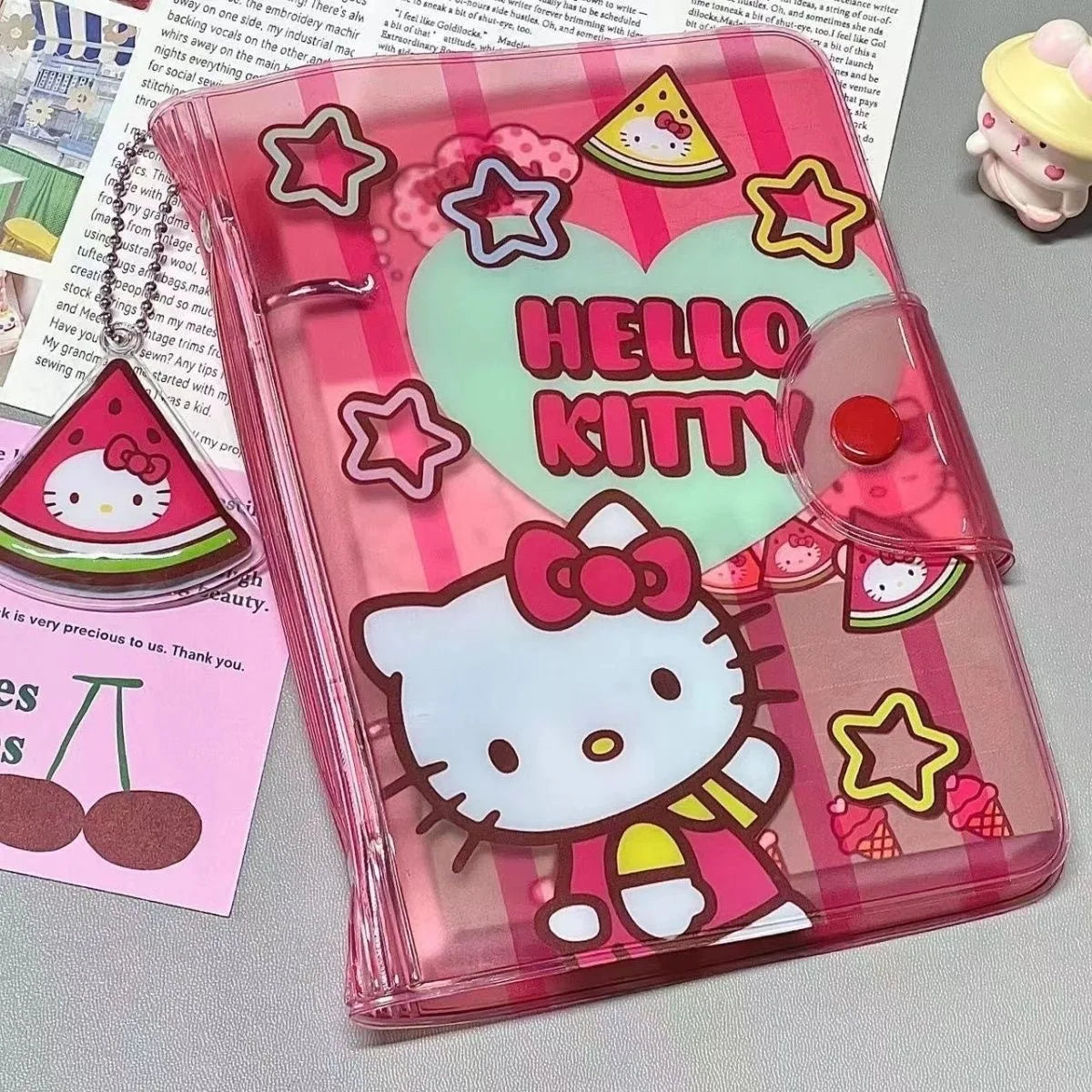 Pink Hello Kitty planner cover with star and pizza designs on a gray surface.