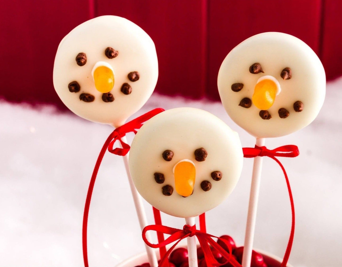 Handmade Christmas snowmen Oreo pops with white chocolate coating and festive decorations