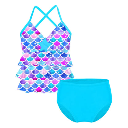 Two-piece swimsuit with mermaid scale top and solid blue bottom on a white background