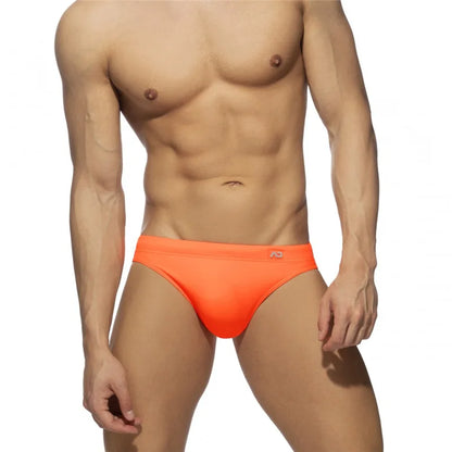Man wearing bright orange men's underwear on a white background