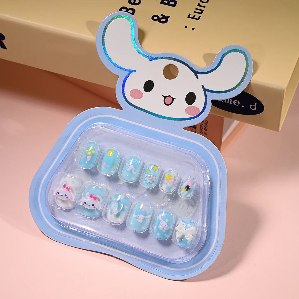 Set of blue nail art designs in a transparent case with a cartoon character lid on a pink background.