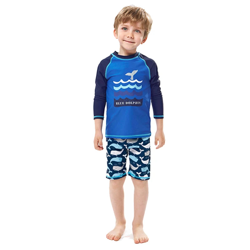 Child wearing a blue and navy swimsuit with whale design on a white background