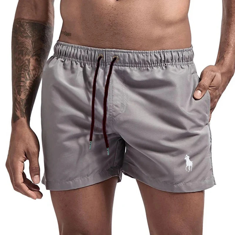 Gray swim shorts with a brand logo on a white background