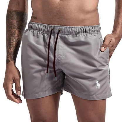 Gray swim shorts with a brand logo on a white background