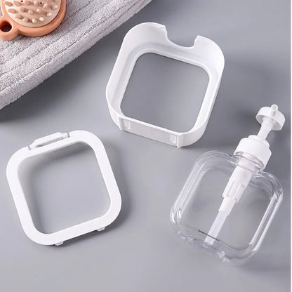 Clear plastic bottle with pump and white square containers on a gray surface