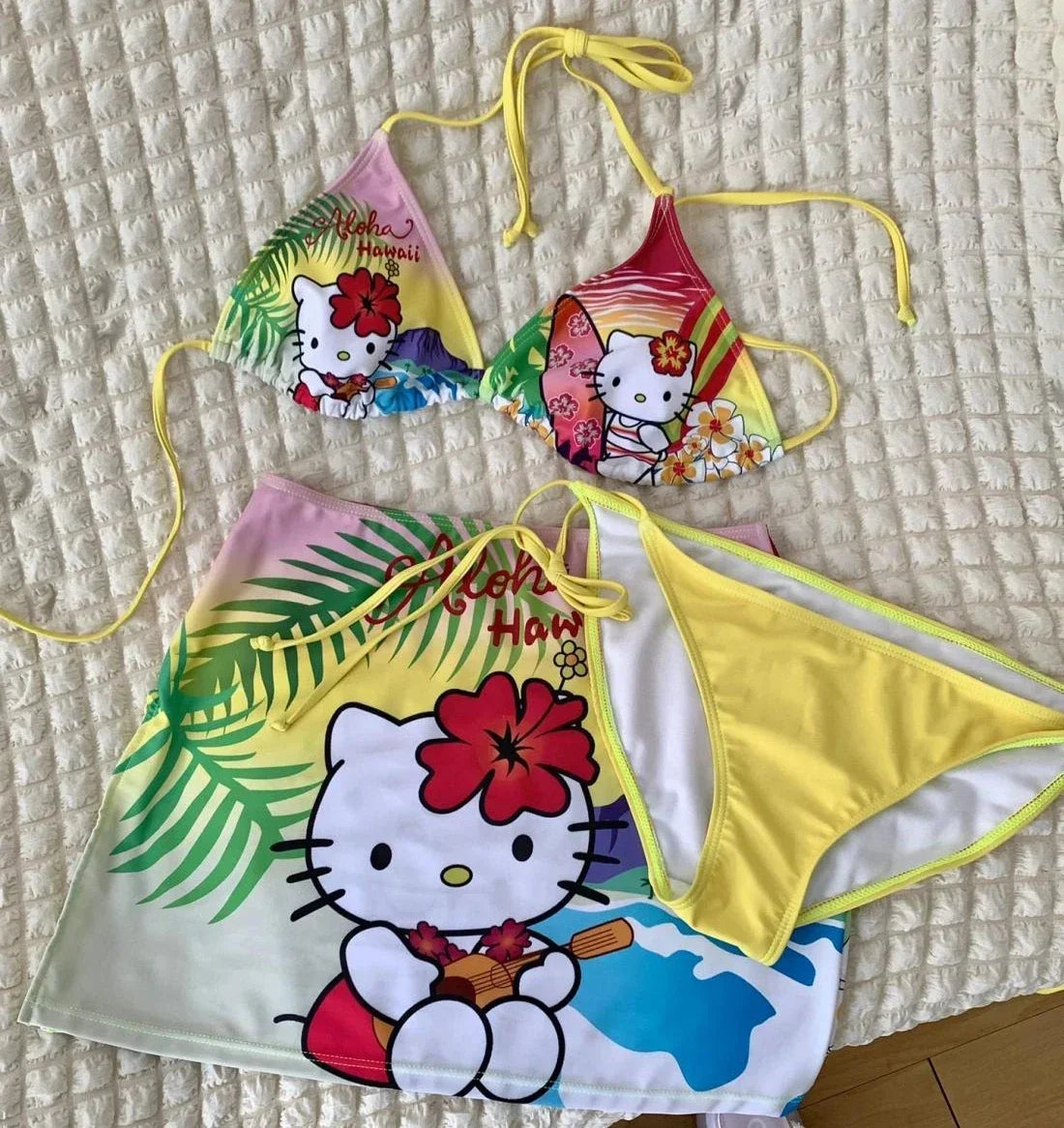 Colorful Hello Kitty bikini set on a textured surface