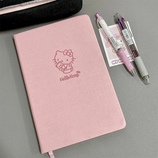 Pink notebook with Hello Kitty logo and two pens on a gray surface