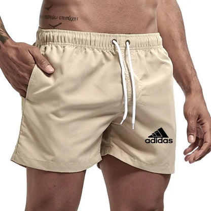 Beige Adidas shorts worn by a person on a white background