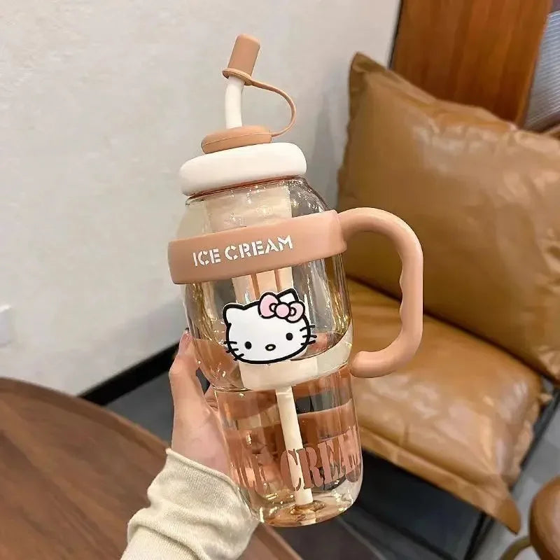 Clear water bottle with pink handle and lid, featuring a cartoon character, held by a person.