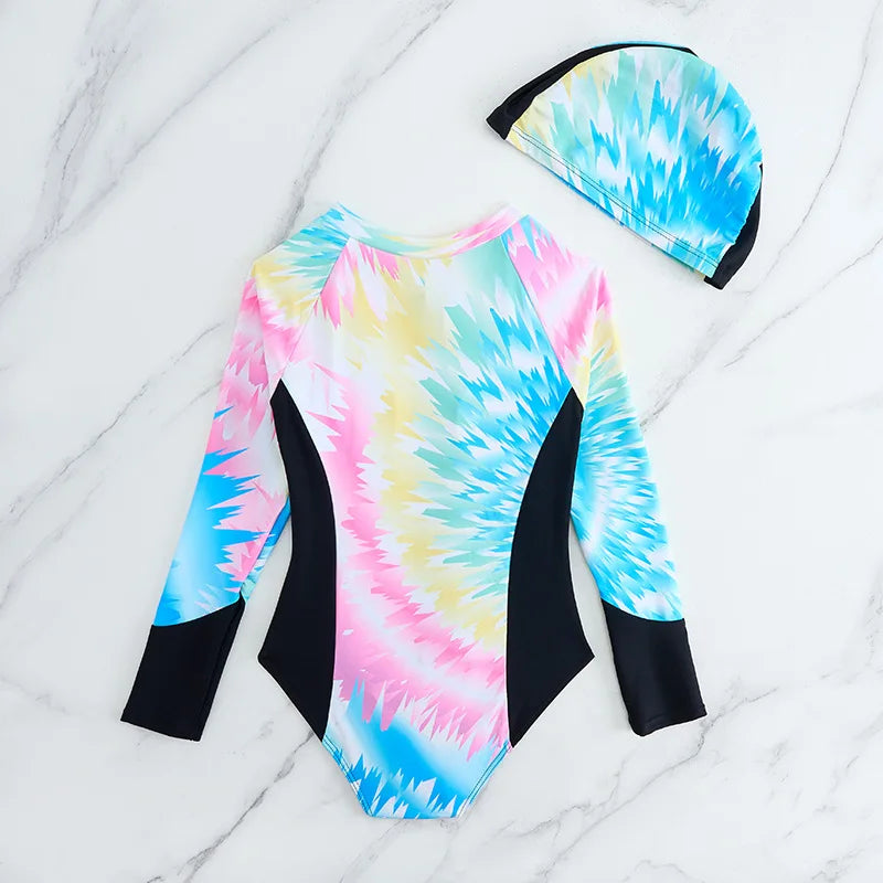 Tie-dye swimsuit with long sleeves and matching cap on a marble surface