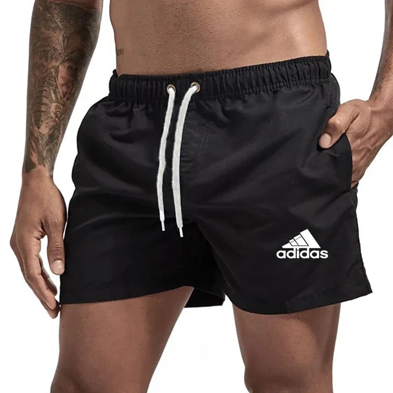 Black Adidas shorts worn by a person on a white background