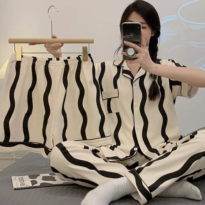 Person wearing a black and white striped pajama set taking a mirror selfie.