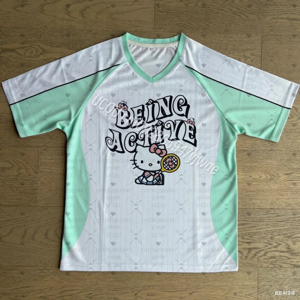 White and green sports jersey with 'Being Active' text and Hello Kitty graphic on a wooden surface