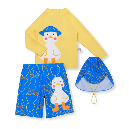 Children's swim set with yellow long-sleeve shirt, blue shorts, and matching hat featuring a cartoon penguin design on a white background.
