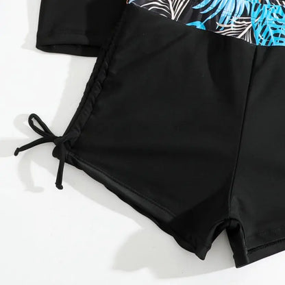 Black swim shorts with a colorful leaf pattern on a white background