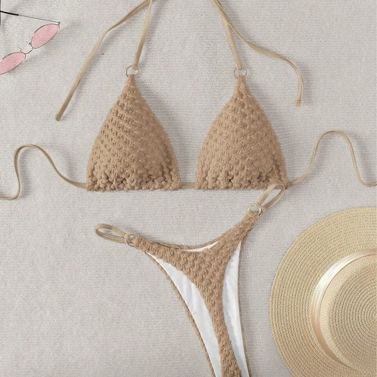 Crocheted bikini set with sunglasses and hat on a light background