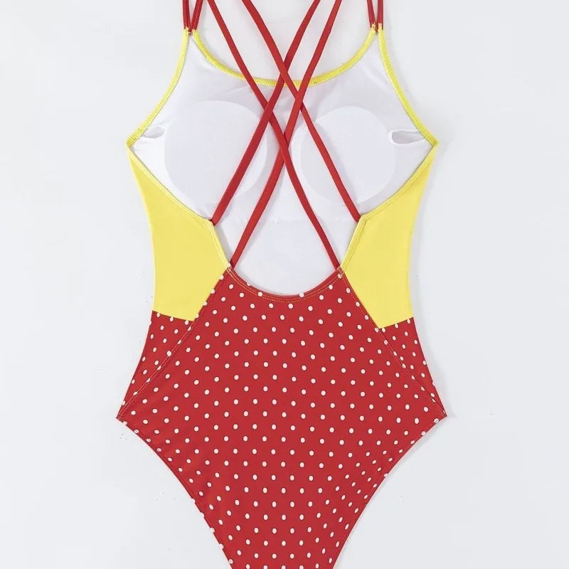 One-piece swimsuit with red polka dot bottom and yellow and red top on a light gray background