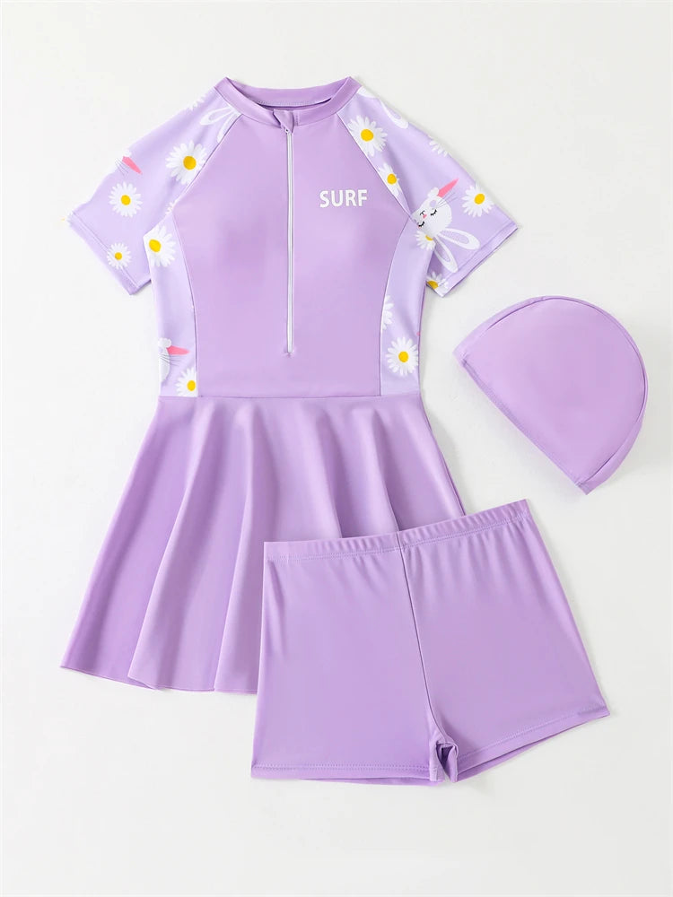 Purple children's swim set with shorts, top, and cap on a white background