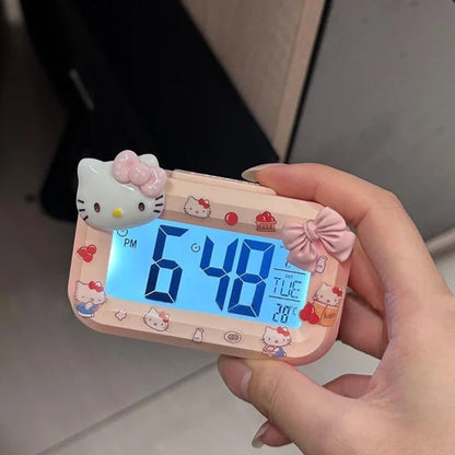 Hello Kitty-themed digital clock held by a hand with a blurred background