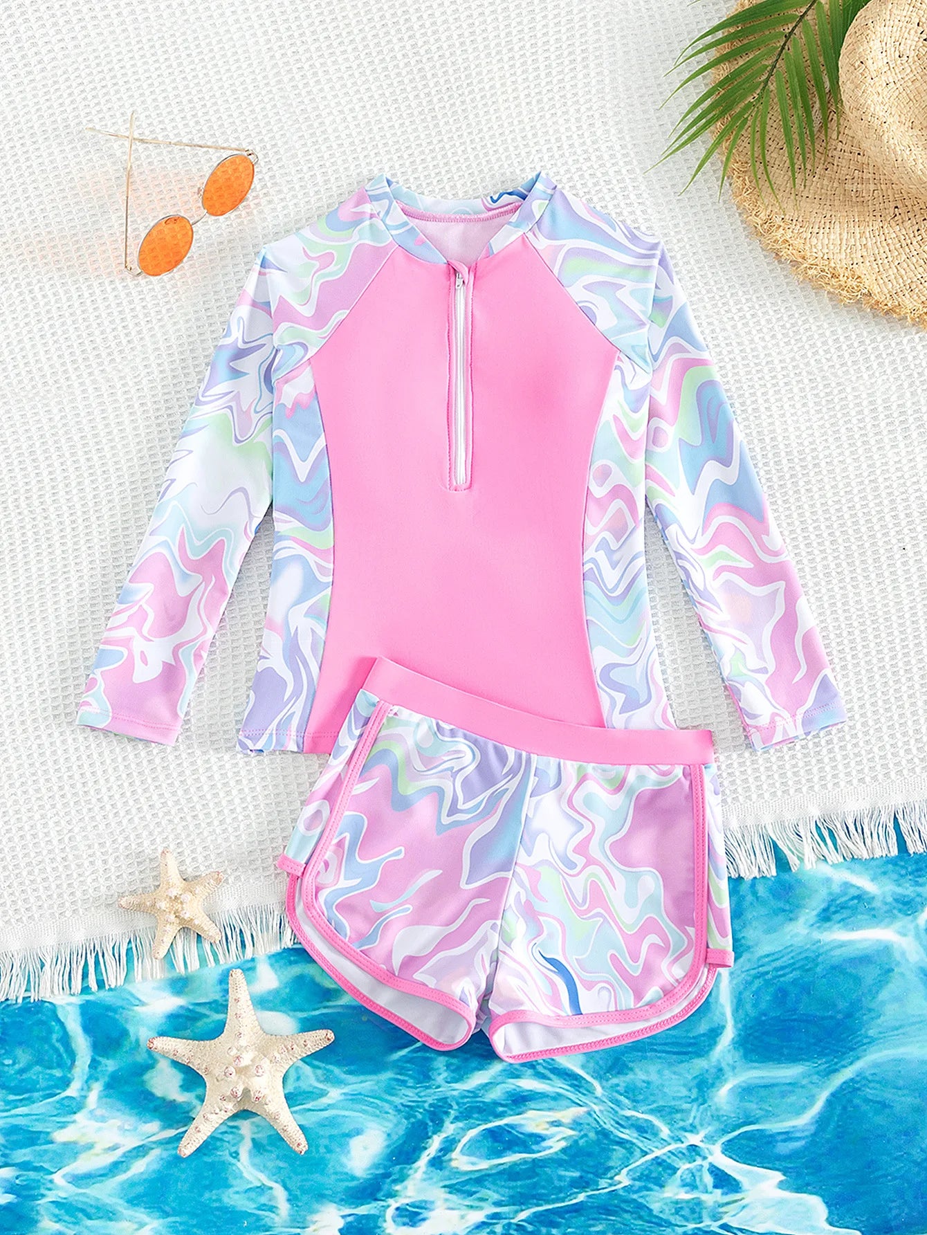 Two-piece swimsuit with long-sleeve top and shorts on a beach setting