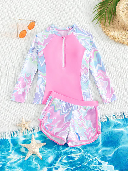 Two-piece swimsuit with long-sleeve top and shorts on a beach setting