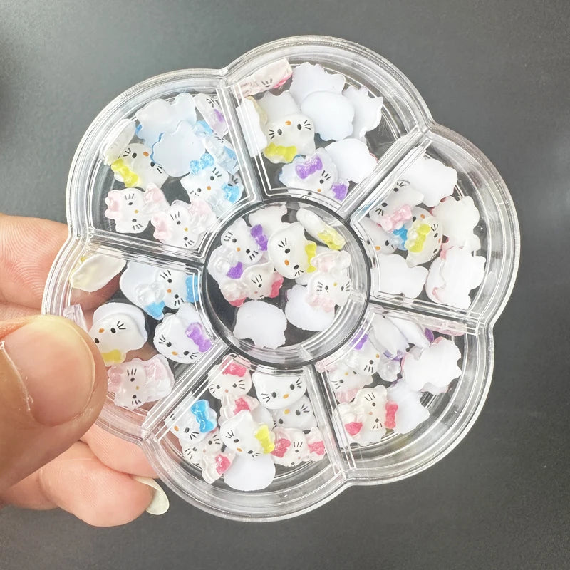 Clear nail art wheel with small decorative items held by a hand against a dark background