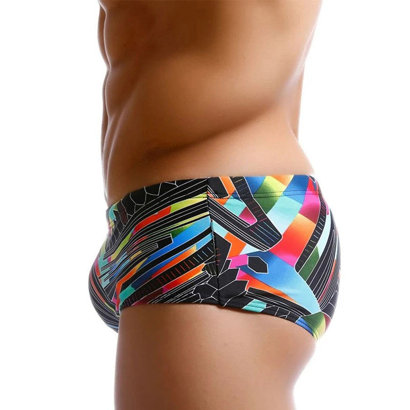 Colorful geometric-patterned swim briefs on a white background