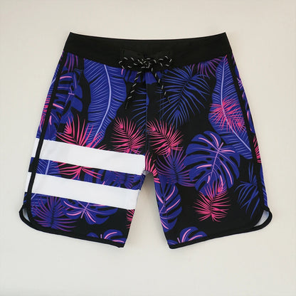 Tropical leaf patterned shorts with a drawstring on a light gray background