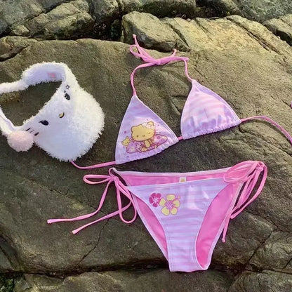 Pink bikini set with cartoon character design on a rocky surface