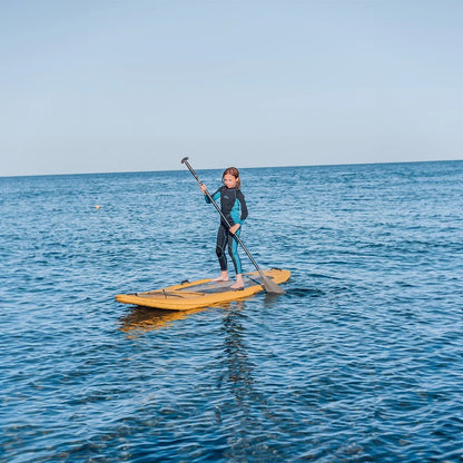 Person paddleboarding on a calm blue ocean with clear skies