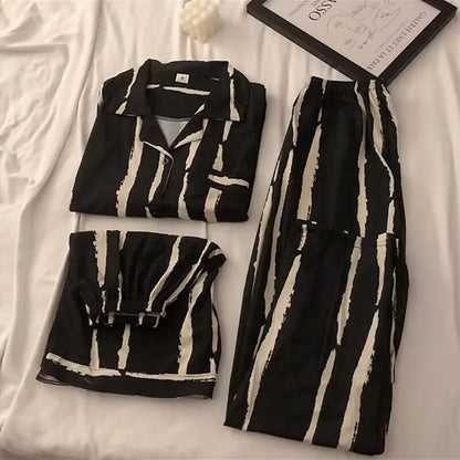 Black and white patterned pajama set on a white surface with a framed picture.