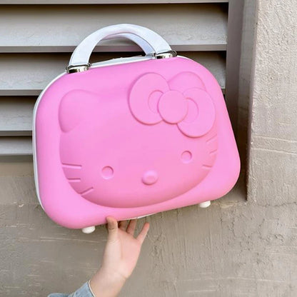 Pink Hello Kitty lunch box held by a hand against a neutral wall.