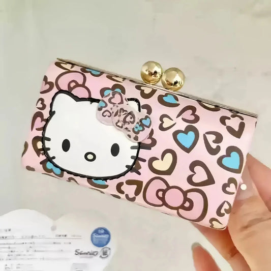 Pink wallet with Hello Kitty design held by a hand against a light background