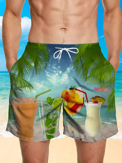 Beach shorts with tropical drink and palm tree design on a blue sky and ocean background.