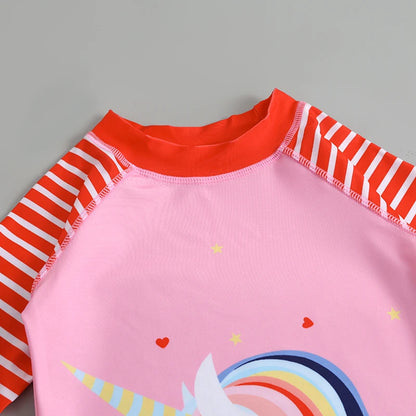 Pink children's swimsuit with red and white striped sleeves on a gray background
