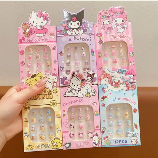 Set of cartoon character nail art packages held by a hand on a wooden surface.