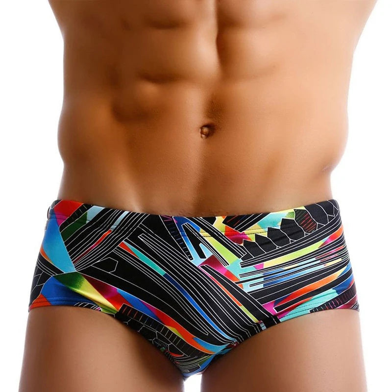 Colorful swim briefs with geometric pattern worn by a person on a white background