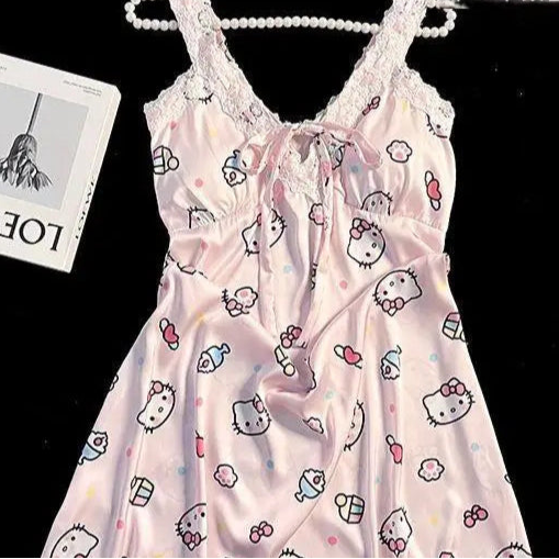 Pink baby dress with cartoon print on a hanger against a black background