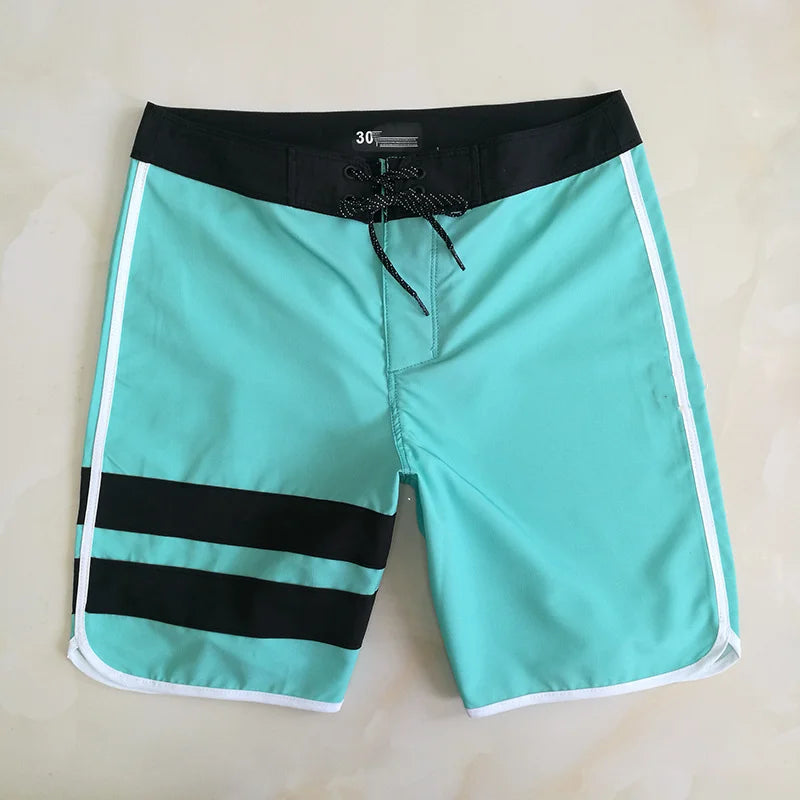 Turquoise shorts with black stripes and a drawstring on a beige background