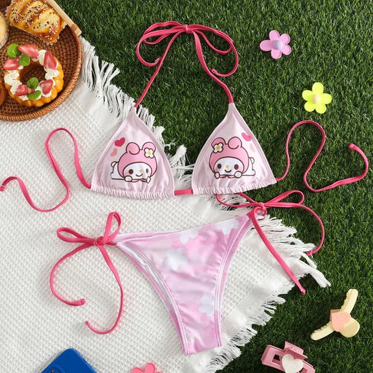 Pink bikini set with cartoon character design on grass with toys and food.