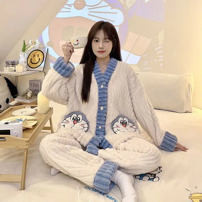 Person wearing a cozy pajama set with cartoon characters, sitting on a bed holding a mug.