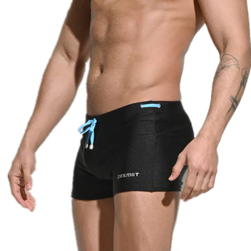 Black swim shorts with a blue drawstring on a white background