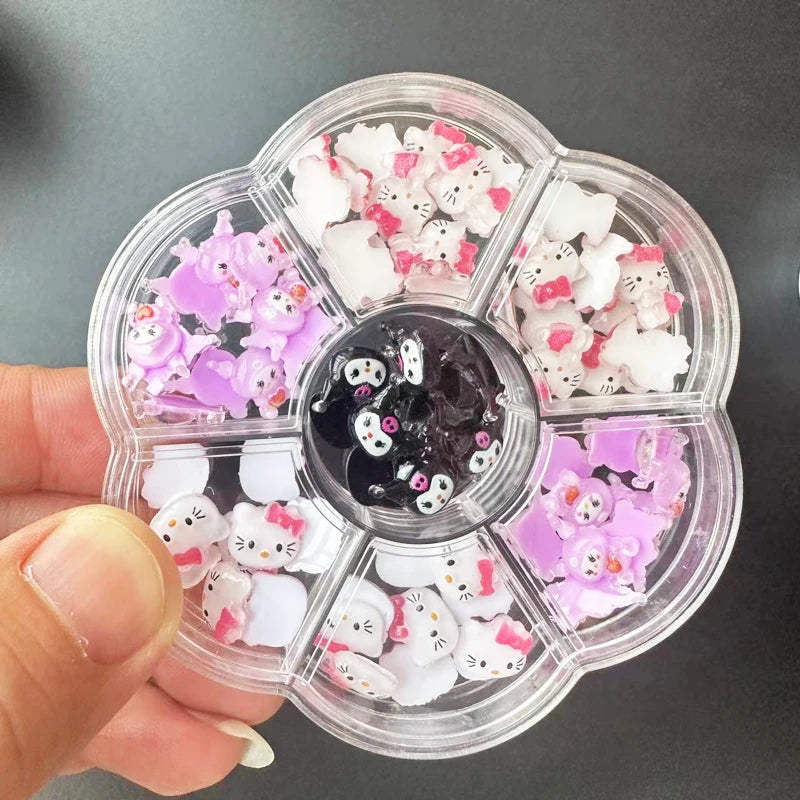 Clear nail art wheel with cat-themed decorations held by a hand against a dark background