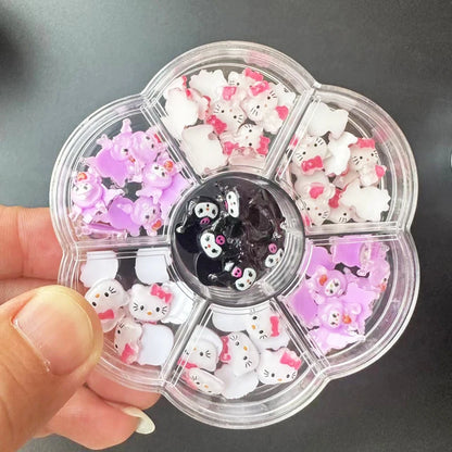 Clear nail art wheel with cat-themed decorations held by a hand against a dark background