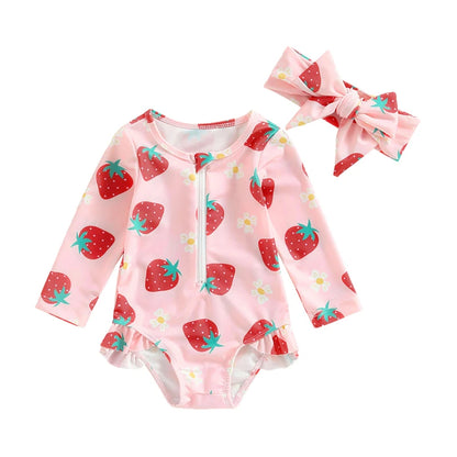 Baby onesie with strawberry pattern and matching headband on a white background