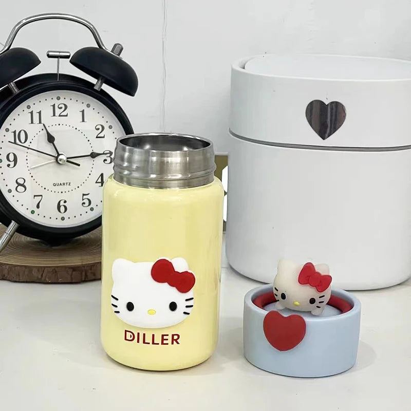 Yellow water bottle with Hello Kitty design and a small figurine on a white surface.