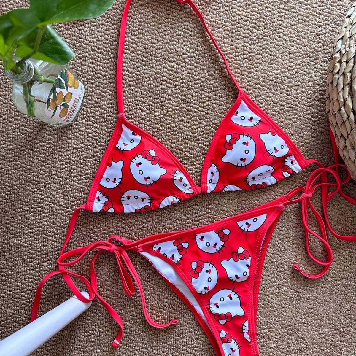 Red bikini set with white cat print on a textured surface