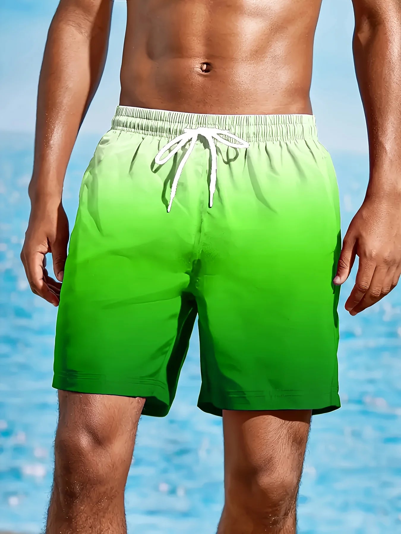 Person wearing green swim shorts with a blue water background