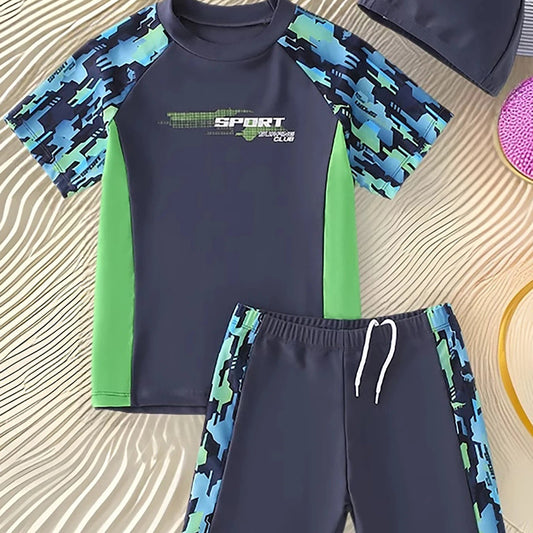 Children's swim set with navy and green patterned shirt and shorts on a textured surface
